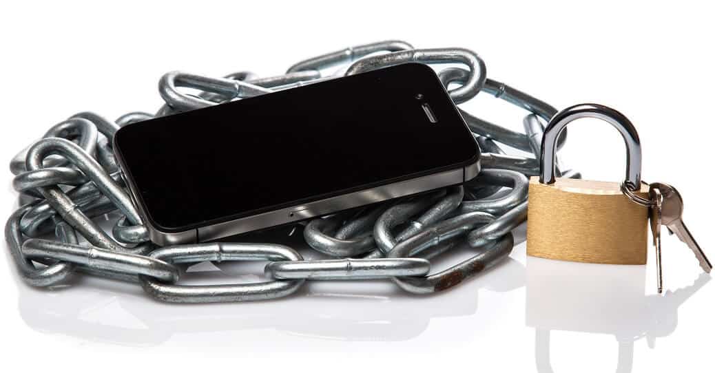 cell phone lying on chain with padlock and keys