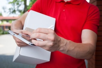 trunk of person in red golf shirt with tablet and stylus